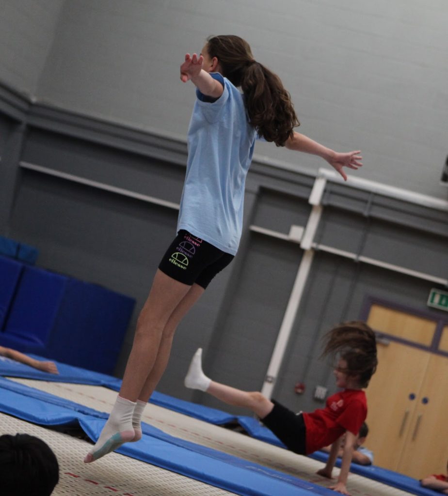 Students are seen trampolining in their PE Kit, during a PE lesson.