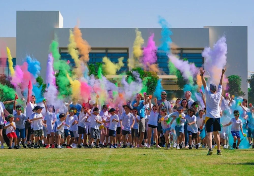 Photo showing a crowd of students running on the school grounds with multi-coloured powder in the air, during the Ebbsfleet Academy Colour Run.