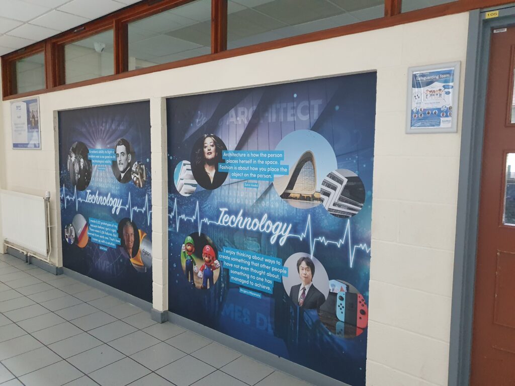 Photo showing a corridor inside the Ebbsfleet Academy building, featuring information and images of different technology-related notable people.