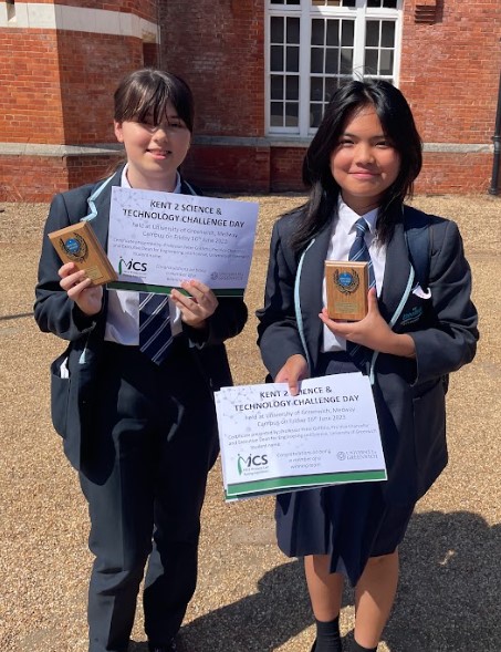 Two year 8 students showing off their trophies and certificates from the event