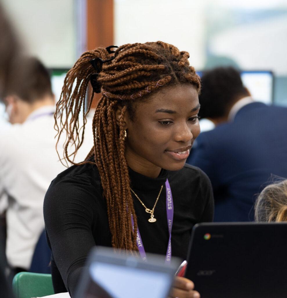 Sixth Form students looking at their Chromebook laptops.