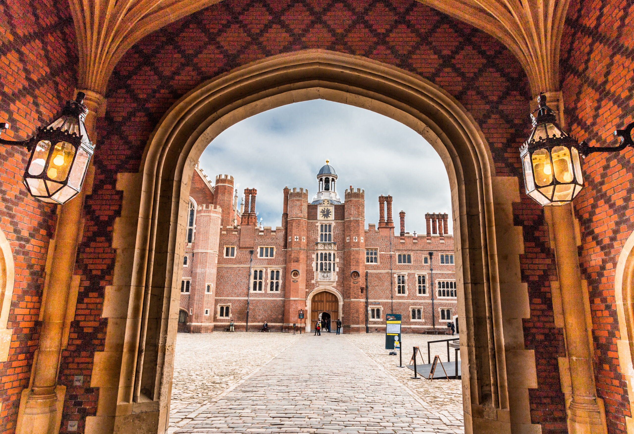 London, UK - 26 October, 2015: exterior image of Hampton Court Palace on a crisp autumn day. Hampton Court Palace is a royal palace in the London Borough of Richmond upon Thames, Greater London, in the historic county of Middlesex, and within the postal town East Molesey, Surrey. It has not been inhabited by the British Royal Family since the 18th century. The palace is 11.7 miles (18.8 kilometres) south west of Charing Cross and upstream of central London on the River Thames. Redevelopment began to be carried out in 1515 for Cardinal Thomas Wolsey, a favourite of King Henry VIII. In 1529, as Wolsey fell from favour, the King seized the palace for himself and later enlarged it. Along with St. James's Palace, it is one of only two surviving palaces out of the many owned by King Henry VIII. Horizontal colour image.
