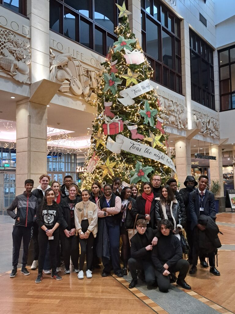 KS5 students stood together in front of a Christmas tree