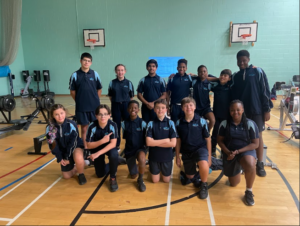 Participants in a Rowing Competition at Sir Joseph Williamson's Mathematical School pose for the camera in a group photo in the Sports Hall.