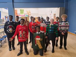 A group of students are pictured smiling for the camera and wearing their Christmas jumpers in celebration of Christmas Jumper Day 2023.