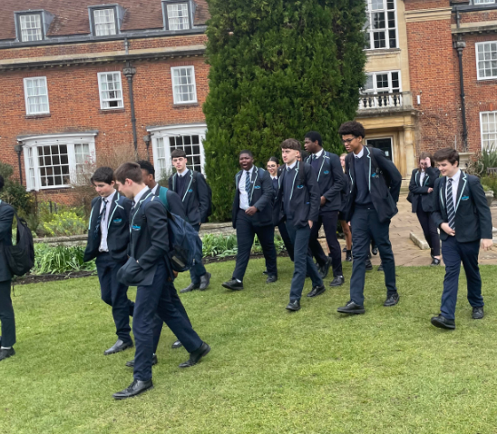 Year 11 and 12 students from Ebbsfleet Academy are pictured walking across an outdoor space on the grounds at Oxford University during a school trip there.