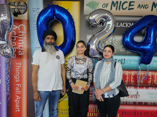 A female Post-16 student is pictured smiling for the camera, alongside both her parents, after having opened her A-Level results.