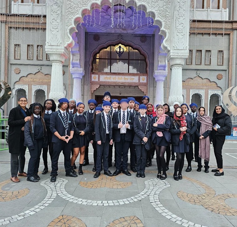 A group of students smiling for a photo outside the Gurdwara