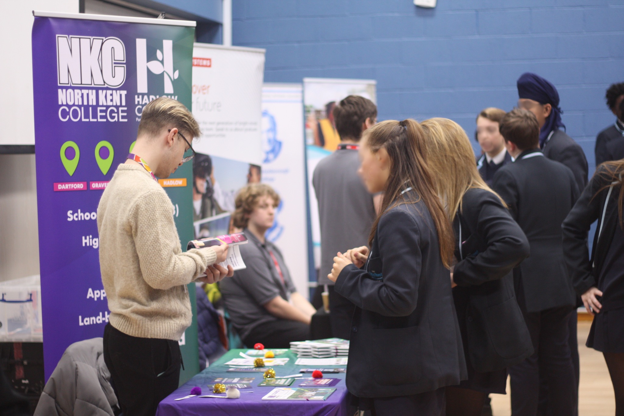 Two students talking to someone at a stall