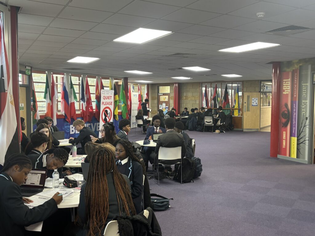 Students sat around tables completing work and supporting one another